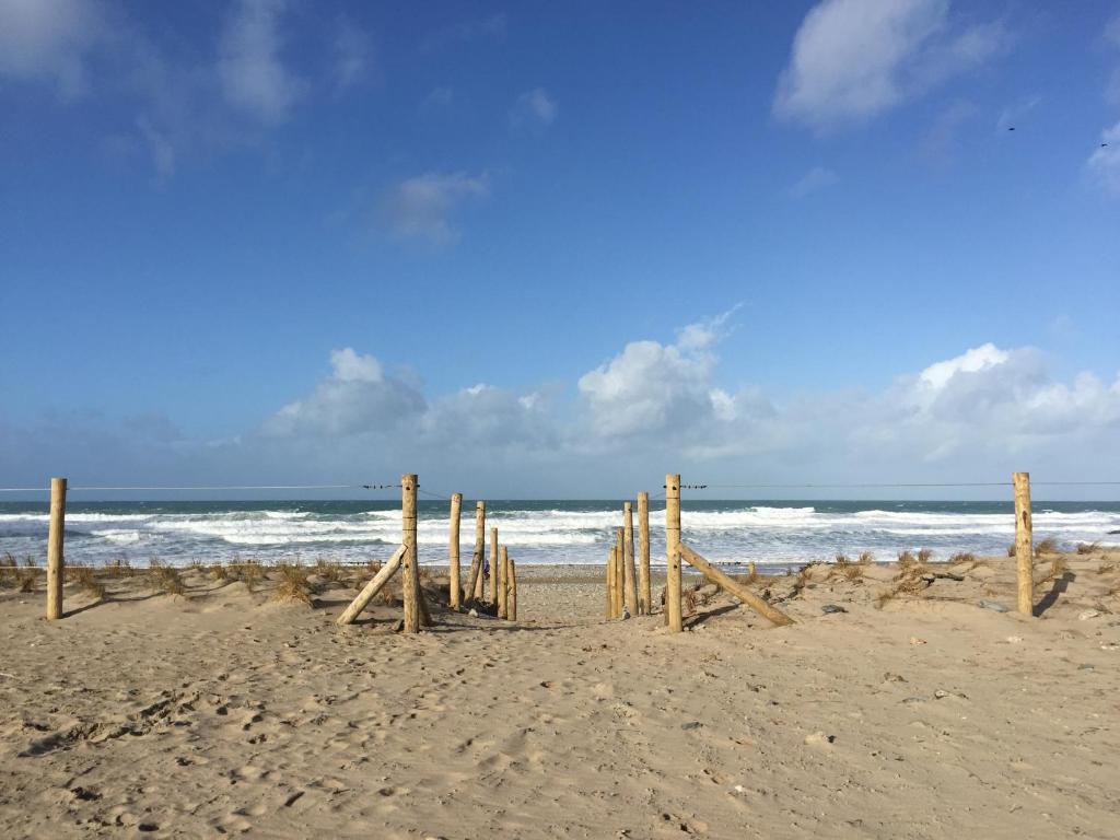 a wooden fence on the beach near the ocean at Mount Hawke Holiday Bungalows in Porthtowan