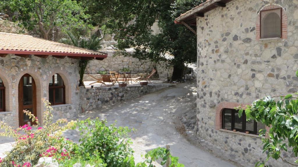a stone house with a patio and a building at Fattoria Armonia in Stilo