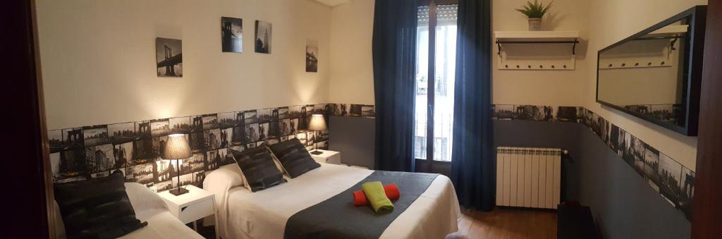 sypialnia z łóżkiem, kanapą i oknem w obiekcie Pension Aries w mieście San Sebastián