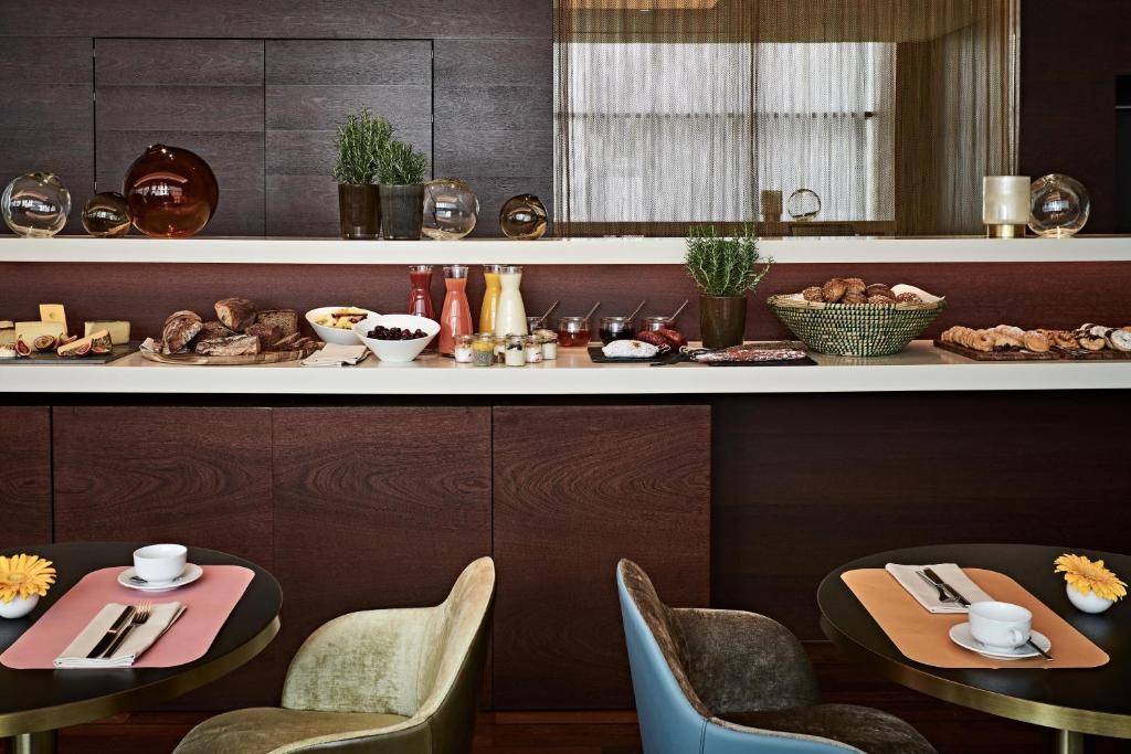 a restaurant with two tables and chairs and a counter at SIDE, Hamburg, a Member of Design Hotels in Hamburg