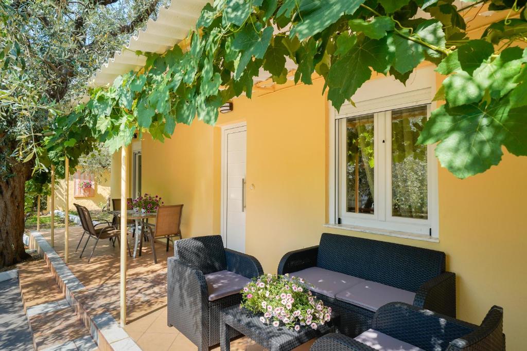 eine Terrasse mit Stühlen, einem Tisch und einem Fenster in der Unterkunft Kritiri House in Skala Kallirachis