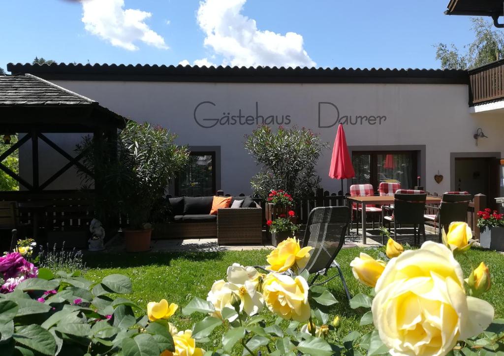 um jardim em frente a uma casa com rosas amarelas em Gästehaus Daurer em Reinsberg