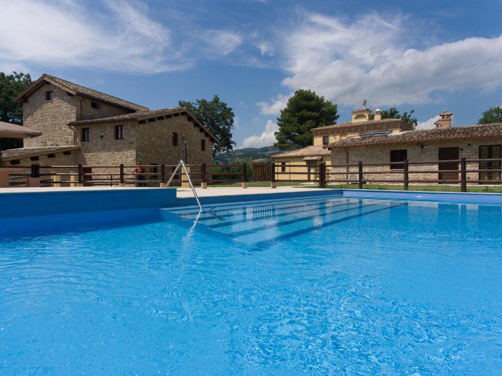 a swimming pool in front of a house at BorgoPratole CountryHouse in Cingoli