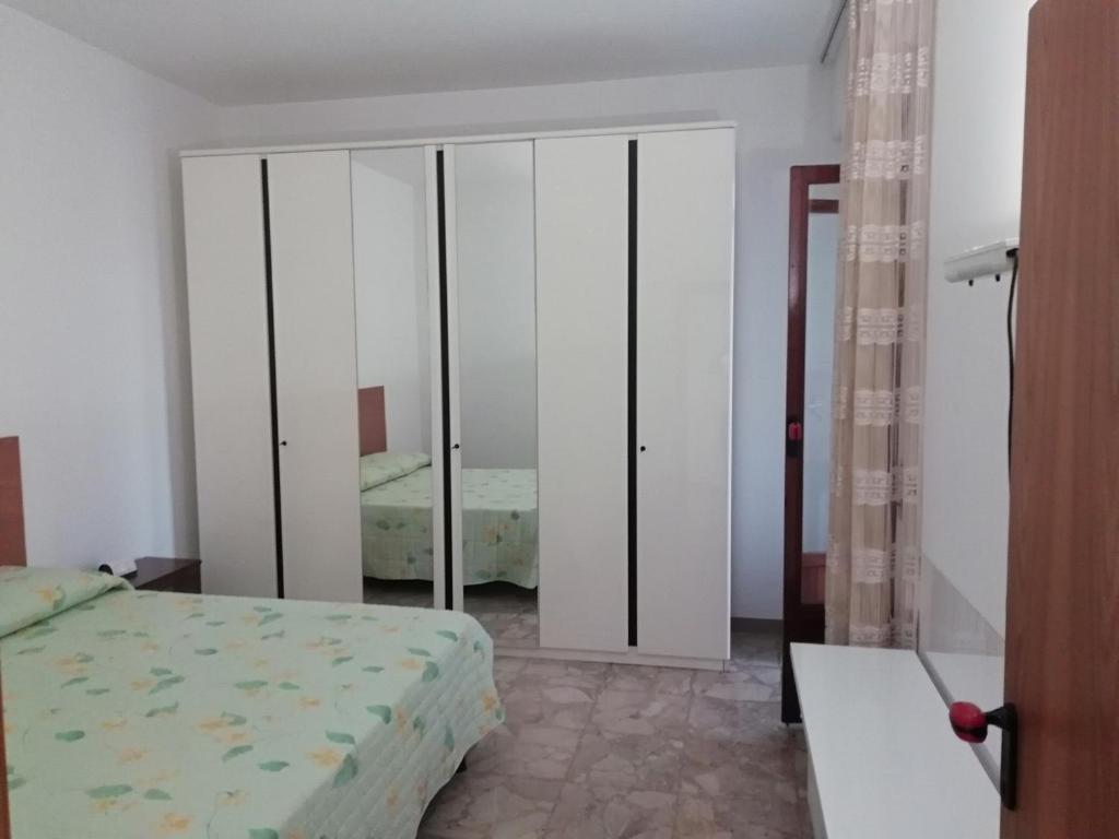 1 dormitorio con cama y armario con espejo en Casa vacanze La rosa bianca en San Benedetto del Tronto