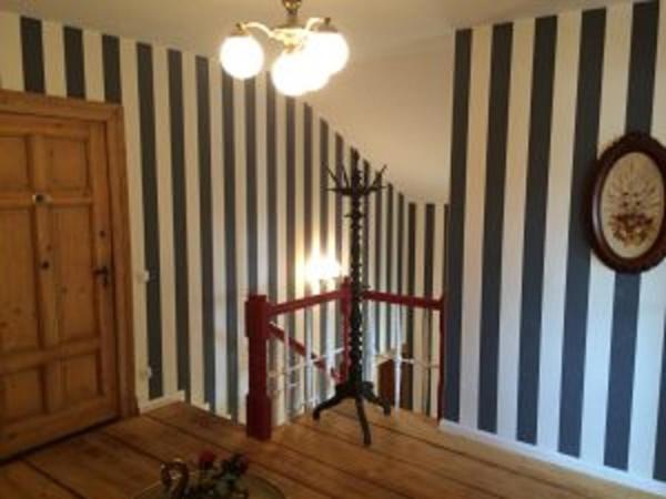 a hallway with a room with striped walls and a clock at Traumparadies in Bad Sulza