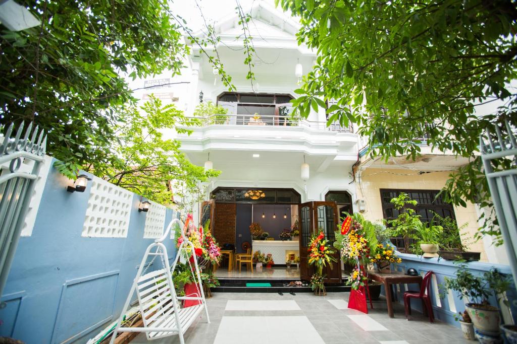 a house with a blue and white fence and trees at Shark Homestay in Hue