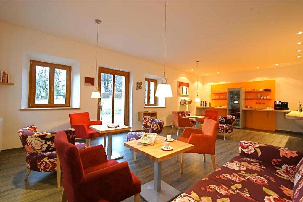 un soggiorno con tavolo e sedie rosse di Hotel Tschitscher a Nikolsdorf