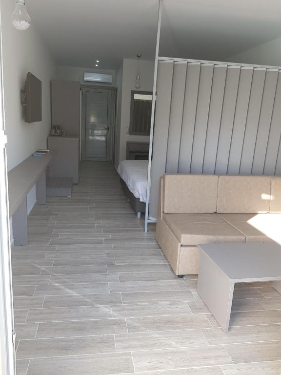 a room with a couch and a bed in it at Thassos Imperial Resort in Skala Rachoniou