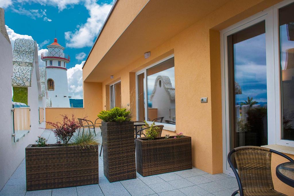 a patio with chairs and a lighthouse in the background at Plaza Beach Holiday House in Prešov