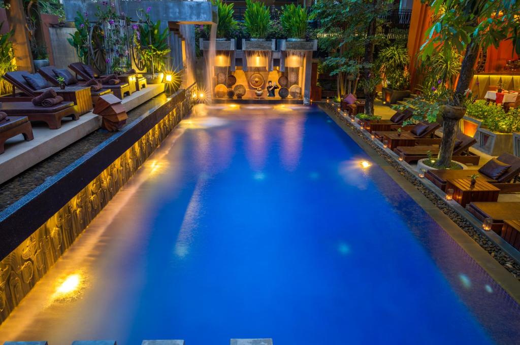 a pool with lights in a hotel at night at Golden Temple Residence in Siem Reap