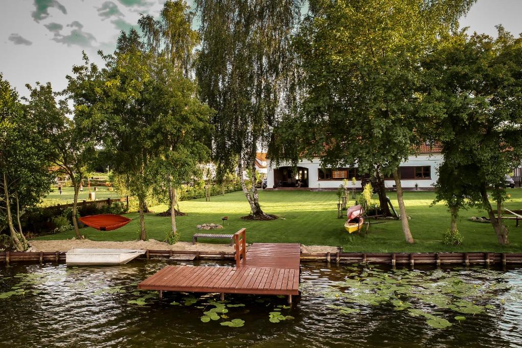 パシムにあるApartView na Mazurach "Osada Zamkowa" by Rent like homeの池の桟橋に座るピクニックテーブル