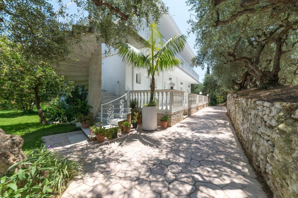 a house with a palm tree on a sidewalk at Ruassi Studios in Amoudi