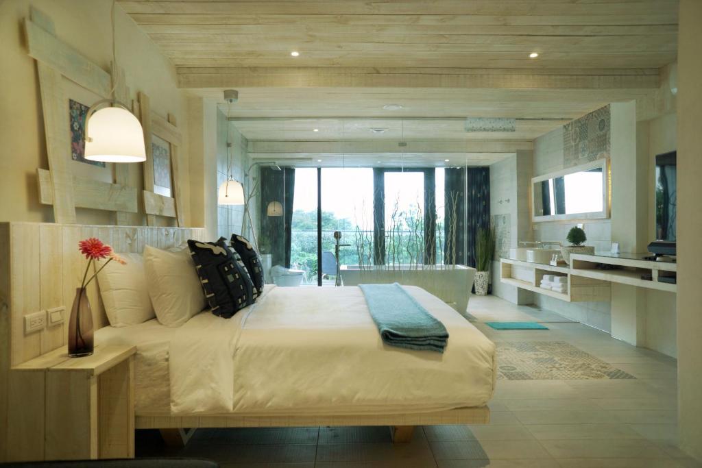 1 Schlafzimmer mit einem großen Bett und einem Badezimmer in der Unterkunft 湛藍海岸民宿 Azure--這個夏天有點藍--墾丁南灣沙灘-可包棟-國旅卡特約店 in Nanwan