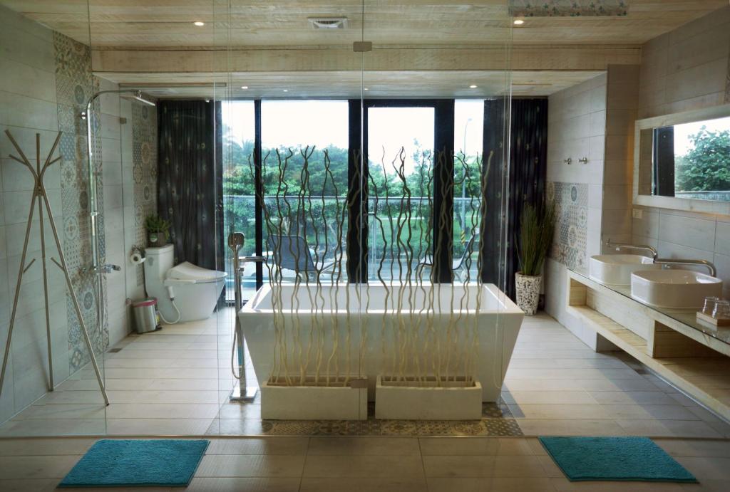 a large bathroom with a tub and two sinks at 湛藍海岸民宿 Azure--這個夏天有點藍--墾丁南灣沙灘-可包棟-國旅卡特約店 in Nanwan