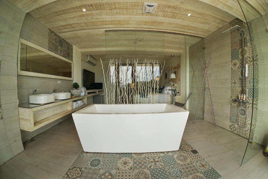 un ampio bagno con vasca bianca in una stanza di 湛藍海岸民宿 Azure-零泊預約居-這個夏天有點藍--墾丁南灣沙灘-可包棟-國旅卡其他業別 a Nanwan