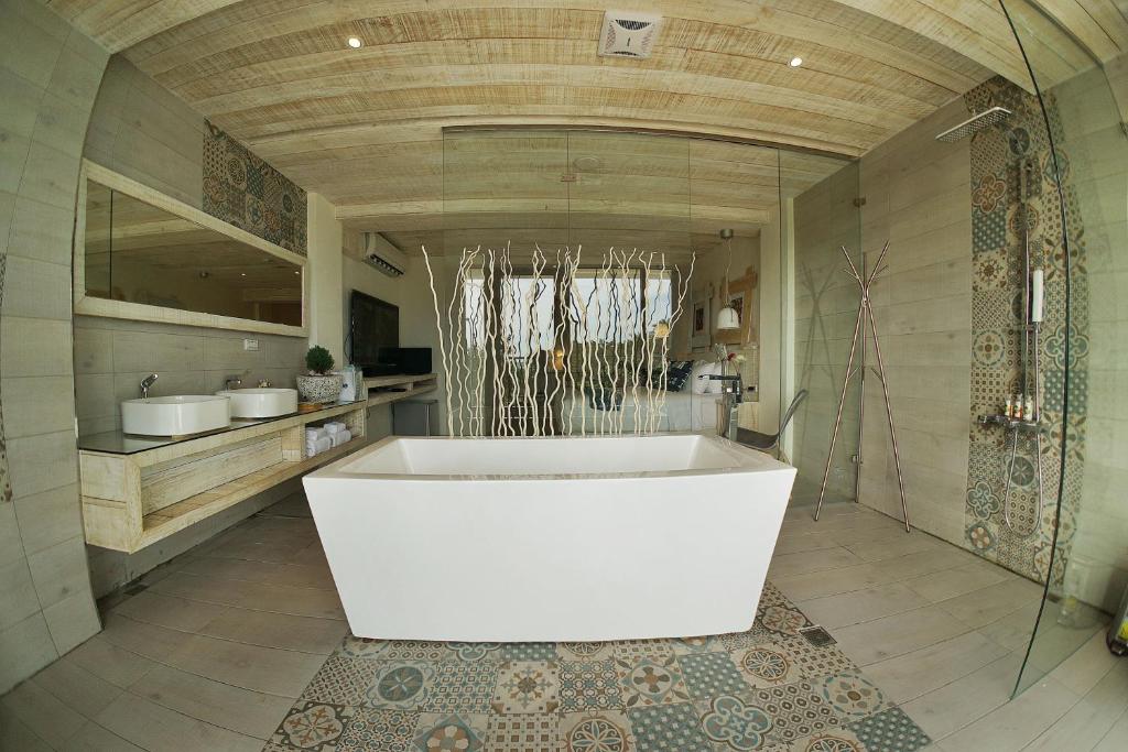 a large bathroom with a white tub in a room at 湛藍海岸民宿 Azure--這個夏天有點藍--墾丁南灣沙灘-可包棟-國旅卡特約店 in Nanwan