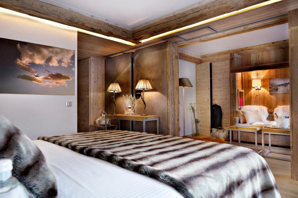 a bedroom with a large bed with wooden walls at Au Coeur du Village in La Clusaz