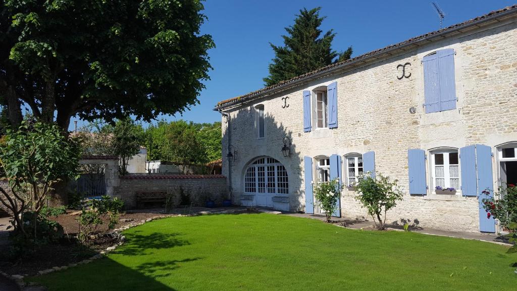 een groot bakstenen gebouw met een grasveld bij La Closeraie in Champagné-les-Marais