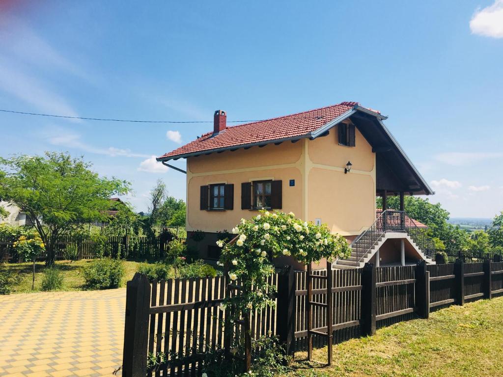 uma casa atrás de uma cerca com um portão em Kuća za odmor Mirna em Cepidlak