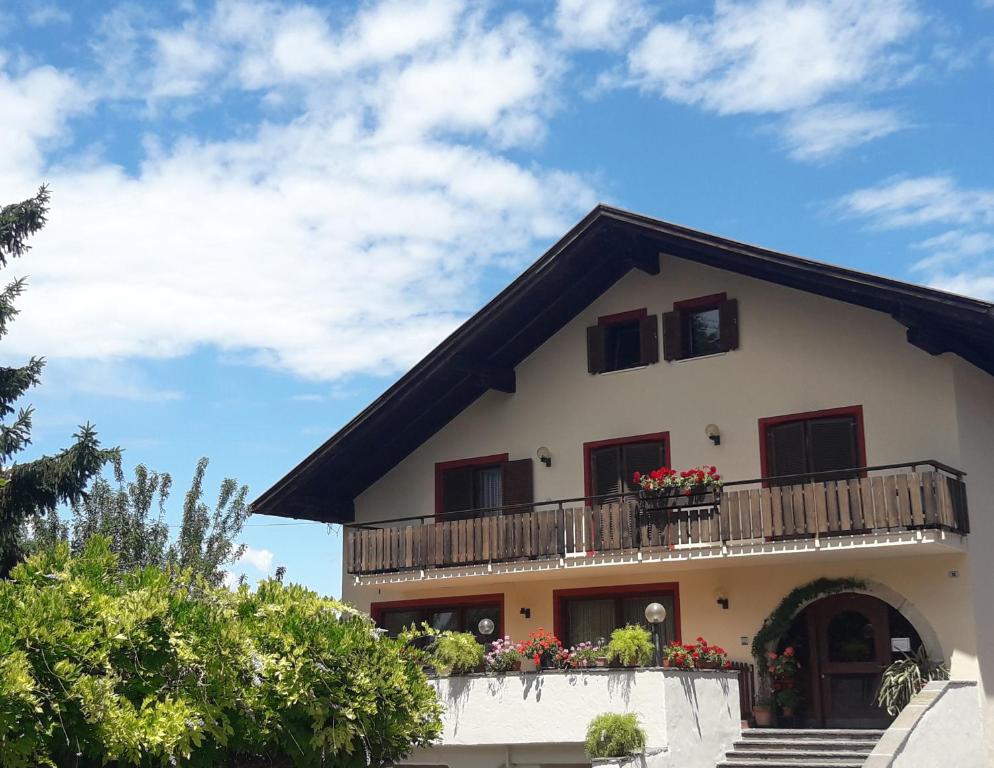 a building with a balcony with flowers on it at Dependance Villnerhof in Egna