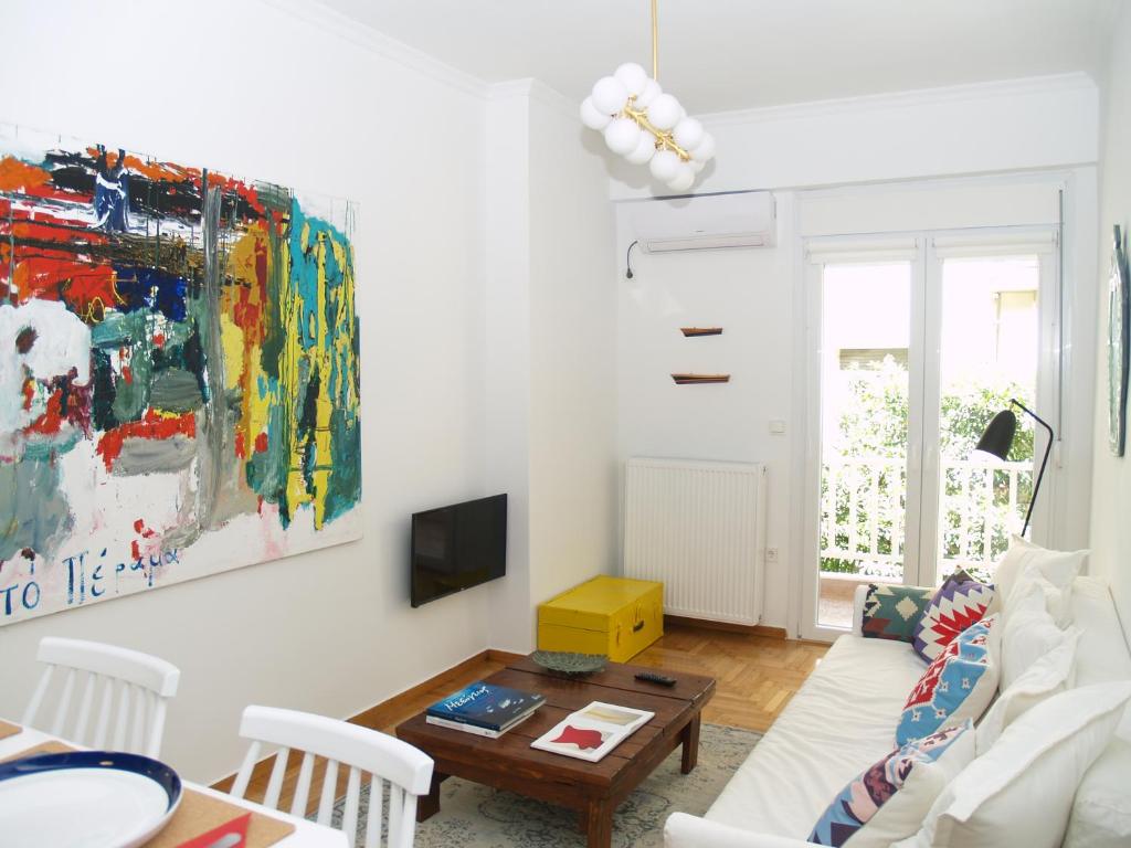 a living room with a couch and a table at A Refreshed & Rich in Details Apartment in Piraeus (Passalimani - Marina Zeas) in Piraeus