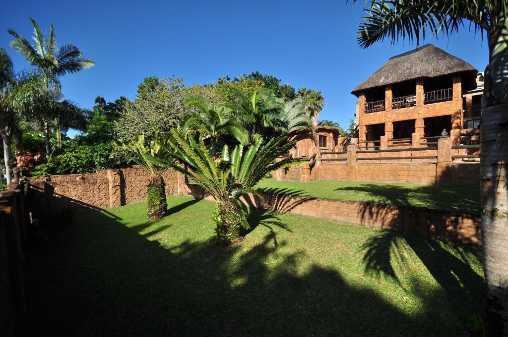 um edifício com uma palmeira em frente a uma parede em Oppi Rotse Guesthouse em St. Lucia