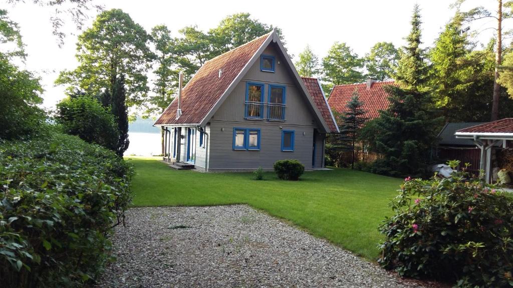 uma pequena casa com um telhado inclinado num relvado em Blue Bird em Pluski