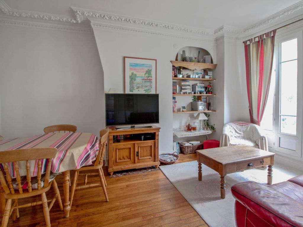 een woonkamer met een televisie en een tafel bij Welkeys - Felix Faure in Parijs