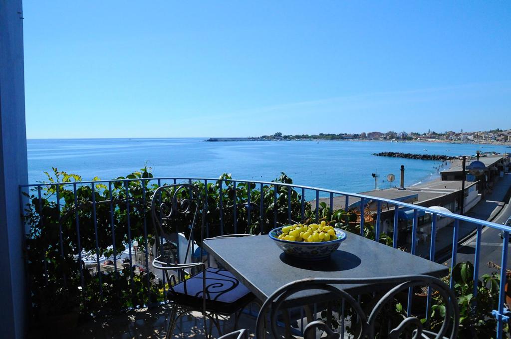 a bowl of fruit sitting on a table on a balcony at Hotel Palladio in Giardini Naxos