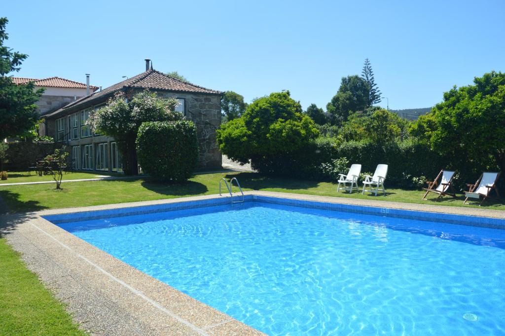 a swimming pool in the yard of a house at Casa Do Carvalho in Viatodos