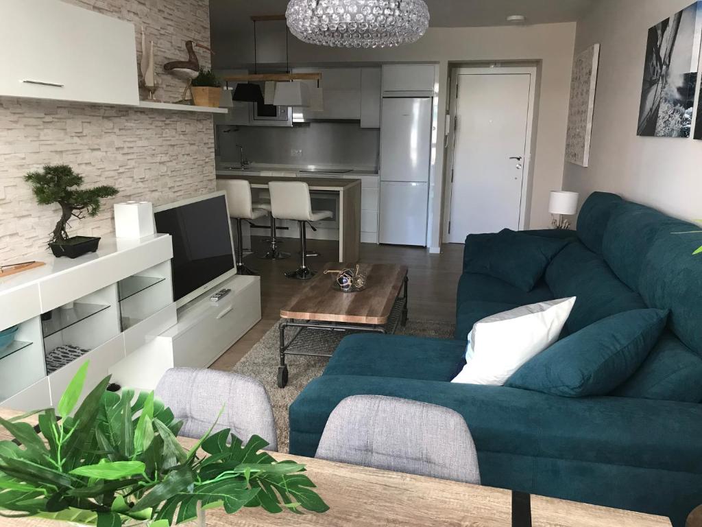 ein Wohnzimmer mit einem blauen Sofa und einem Tisch in der Unterkunft Casa Beiramar, parking gratuíto in Vigo