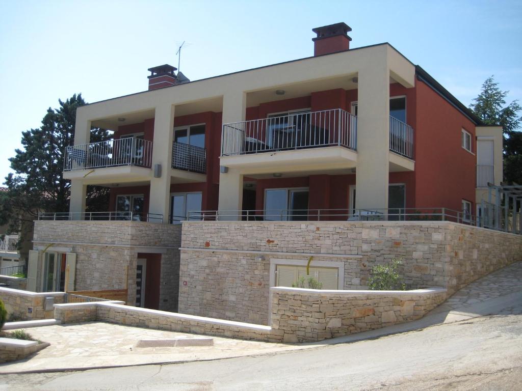 um grande edifício vermelho com varandas no topo de uma parede em VILLA POP Apartments Crveni Vrh em Crveni Vrh