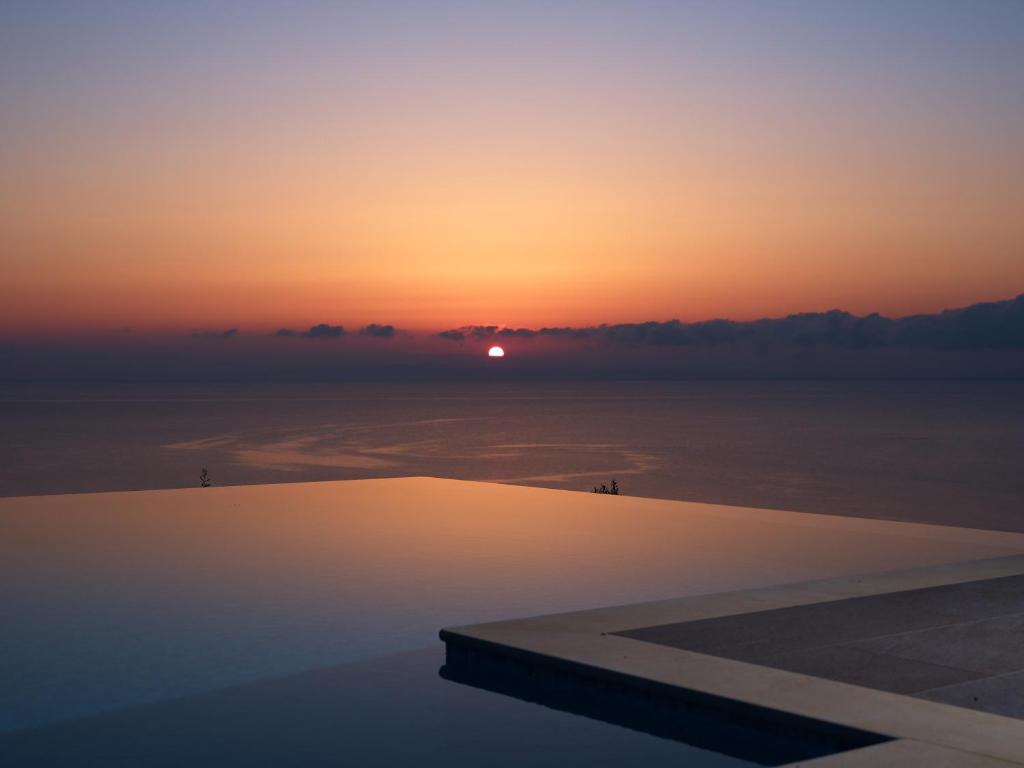 a view of a sunset from a swimming pool at Golden July Luxury Villa in Akrotiri