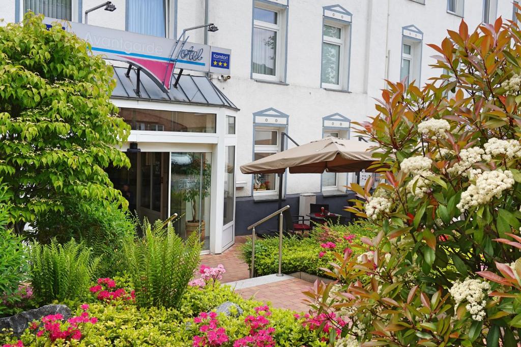 einen Garten vor einem Gebäude mit Blumen in der Unterkunft Avantgarde Hotel in Hattingen