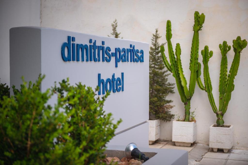ein Schild auf einem Gebäude mit Kaktuen und Pflanzen in der Unterkunft Dimitris Paritsa Hotel in Kos-Stadt