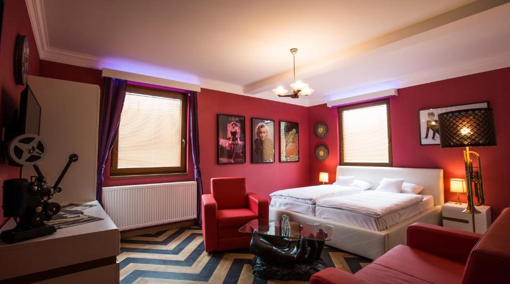 a bedroom with red walls and a bed and a chair at Retro hotel Garage in Ostrava