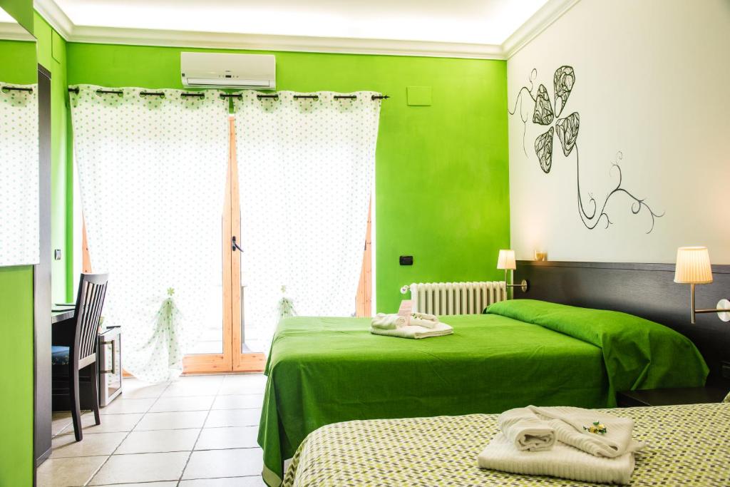 a green bedroom with two beds and a window at Guest House Park in Valmontone