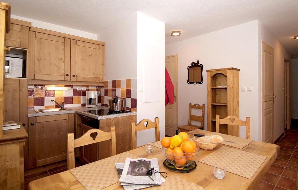 a kitchen with a table with a bowl of fruit on it at Résidence Labellemontagne Rochebrune LE VALLON**** in Orcières