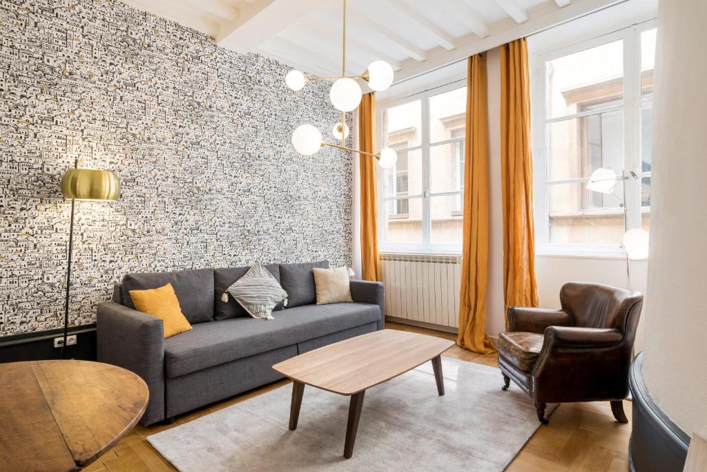 een woonkamer met een bank en een tafel bij Honorê - Suite Trois Maries in Lyon