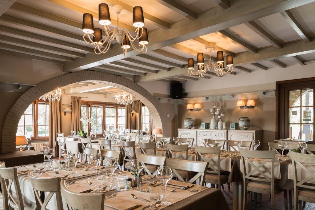 une salle à manger avec des tables et des chaises ainsi qu'un lustre dans l'établissement Hostellerie d'Inzepré, à Barvaux