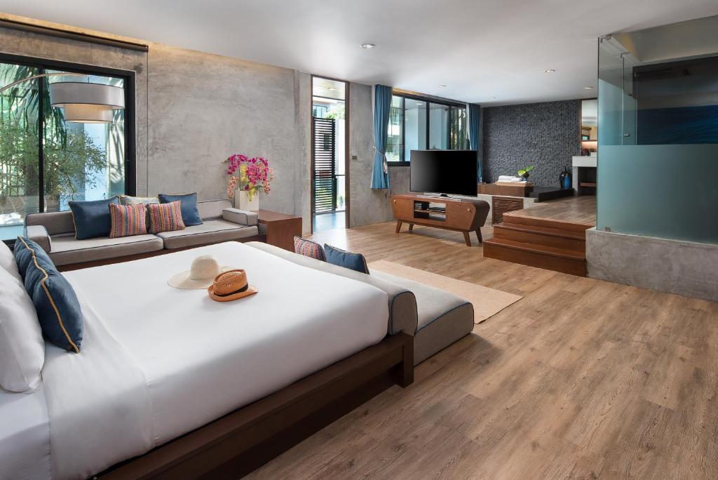 a bedroom with a large bed and a living room at Idyllic Concept Resort in Ko Lipe