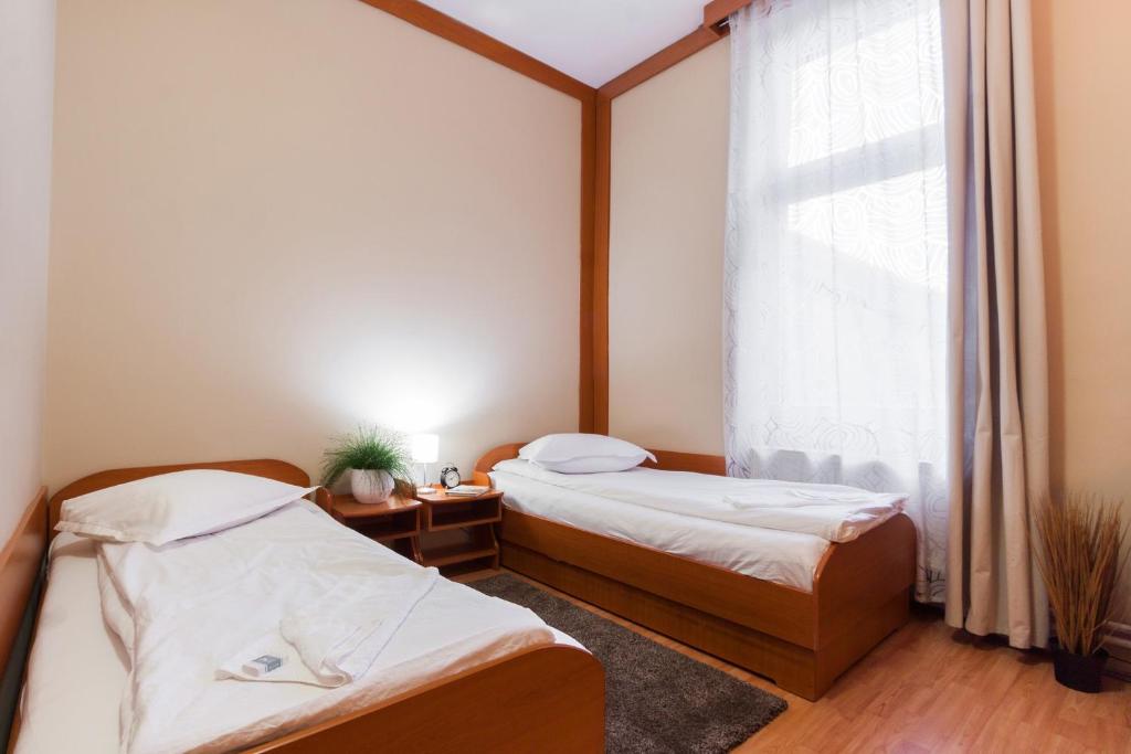 two beds in a room with a window at Szilagyi Hotel&Restaurant in Gheorgheni