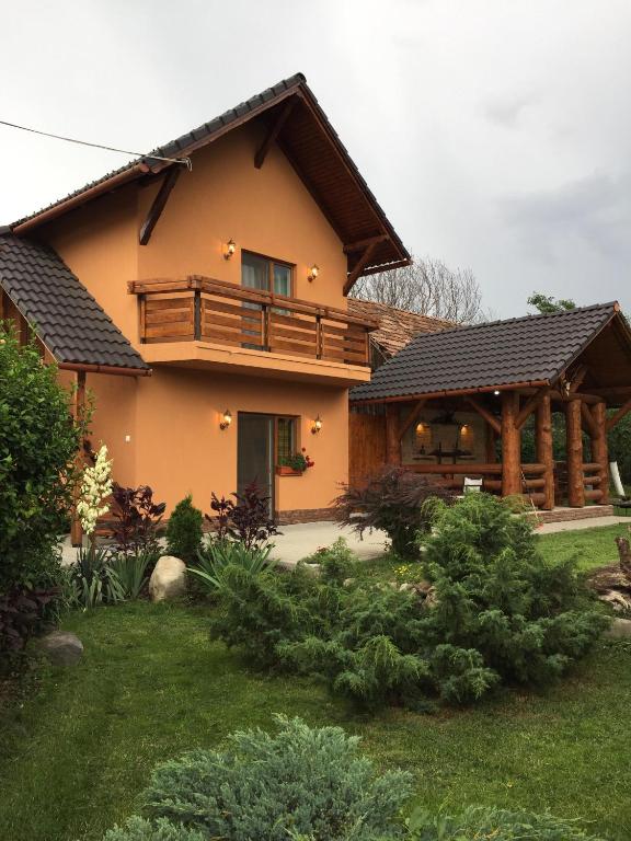 a large house with a balcony and a yard at Casa Tibi in Praid