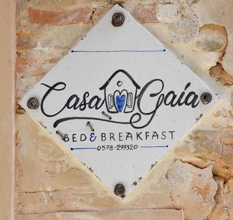 un cartel para un bed and breakfast en una pared de ladrillo en B&B Casa Gaia, en Città della Pieve