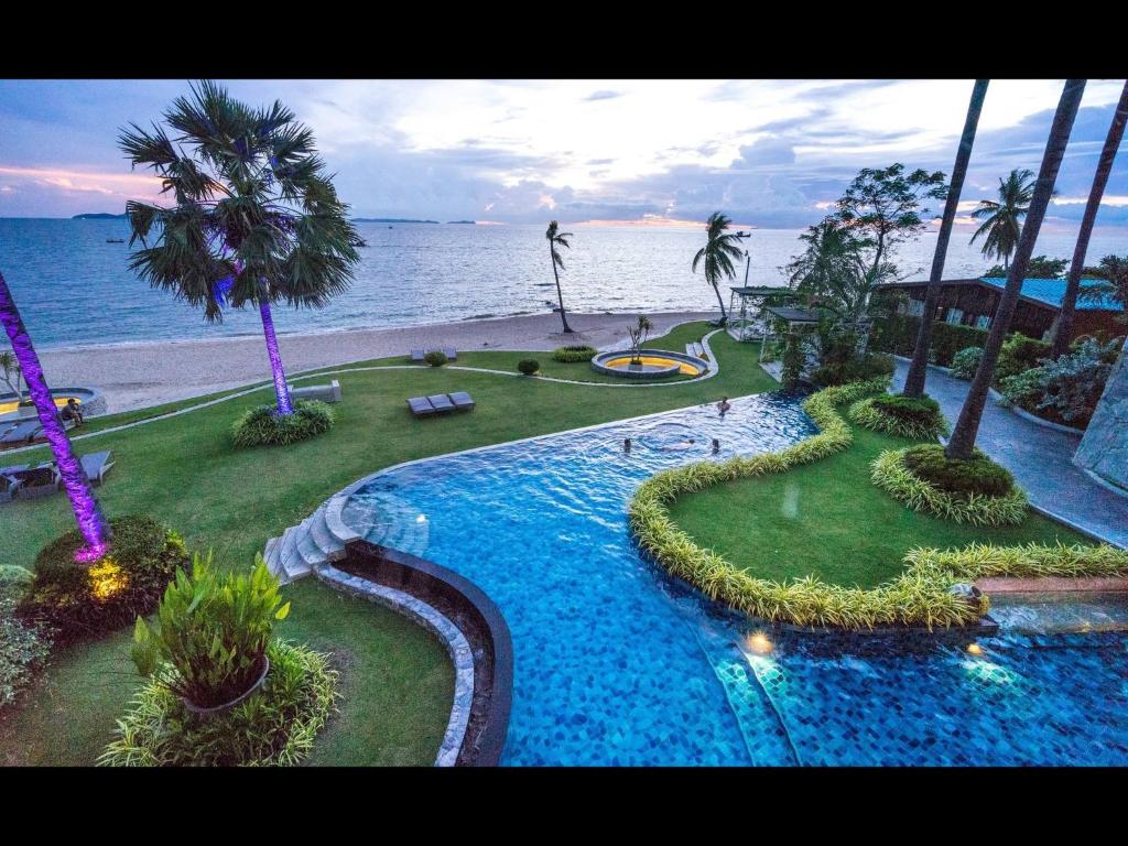 a view of a swimming pool next to the beach at The Palm Beach Front in Pattaya North