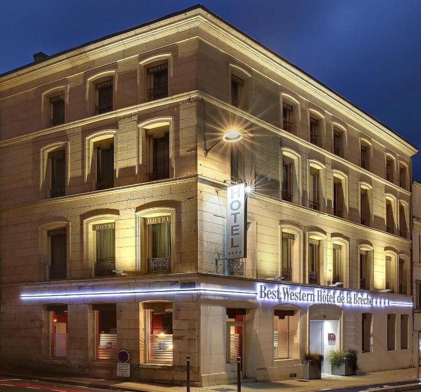 a building on the corner of a street at night at Best Western Hotel de la Breche in Niort
