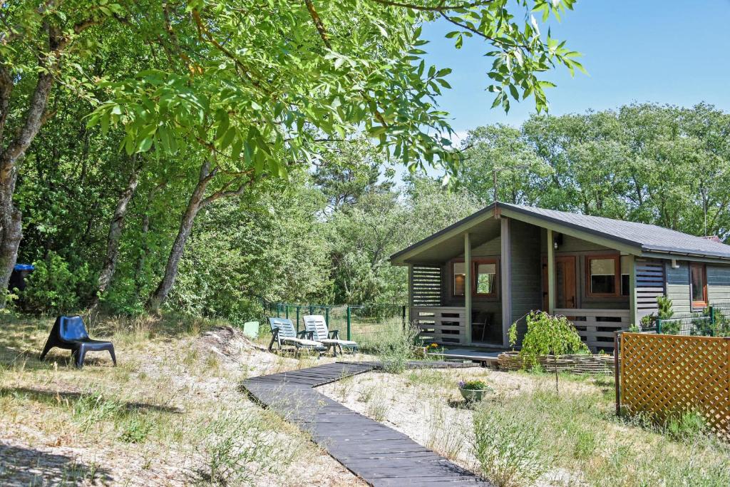 une cabine dans les bois avec un chemin menant à celle-ci dans l'établissement Laimingas Uodas, à Šventoji