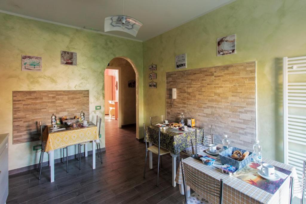 una stanza con tavoli e sedie e un muro di mattoni di Mary's House a Civitavecchia