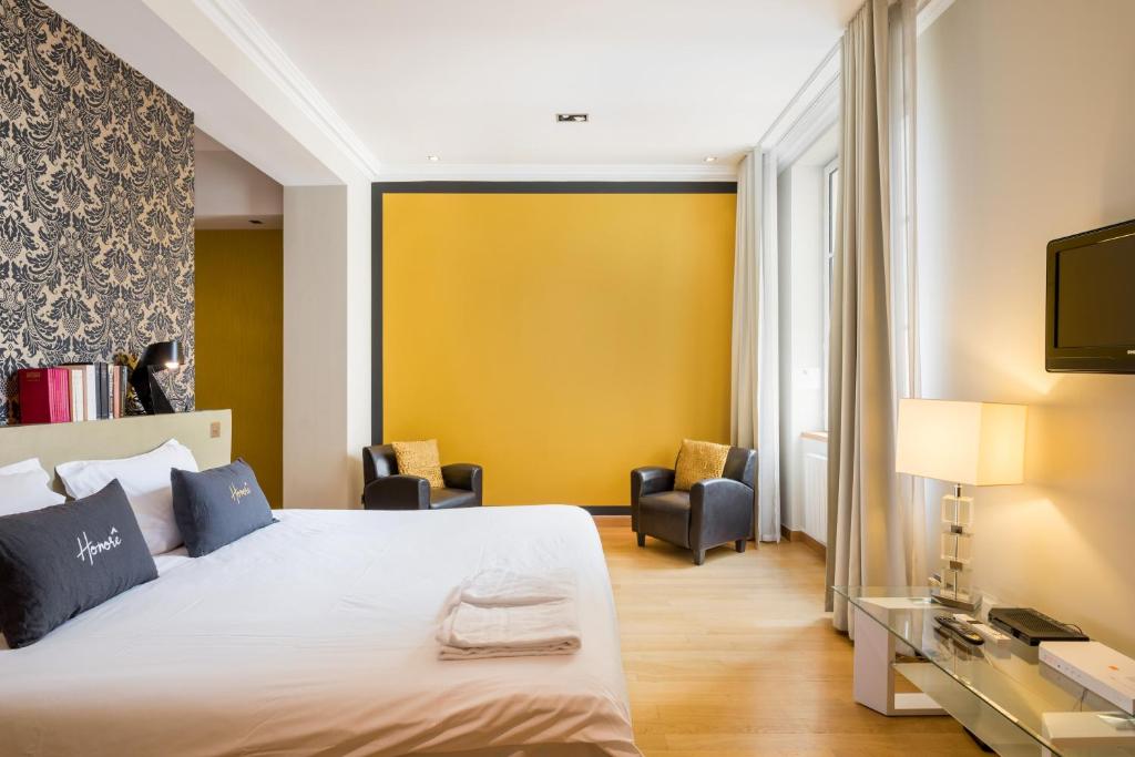 里昂的住宿－Honorê - Suites Bellecour，酒店客房,设有床和黄色的墙壁