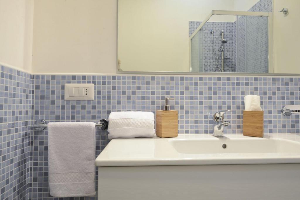 a bathroom with a white sink and blue tiles at Blue Sea Villas by Wonderful Italy in Ostuni